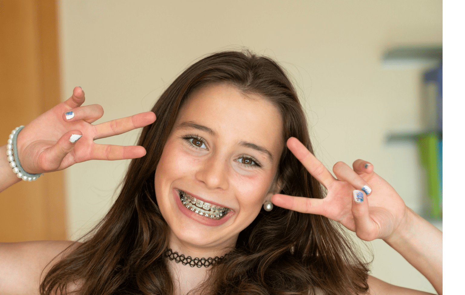 Smiling girl with colorful Wild Smiles braces making a peace sign