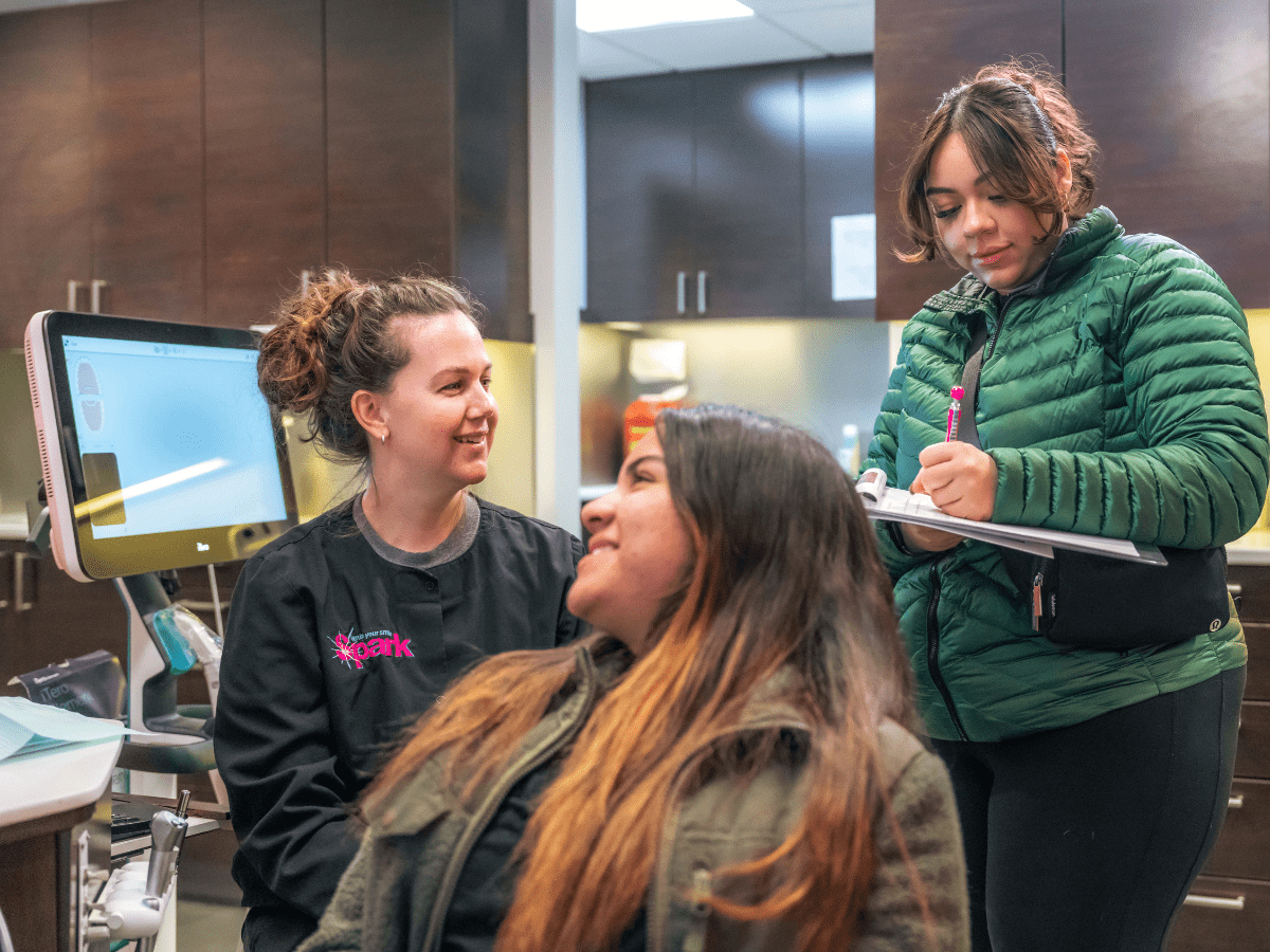 Spark Orthodontics team member consulting with a patient and family member about the Family Discount Plan