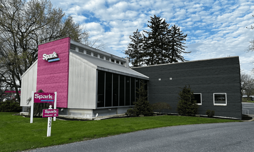 Modern building exterior with pink Spark Orthodontics signage at the Camp Hill, PA office