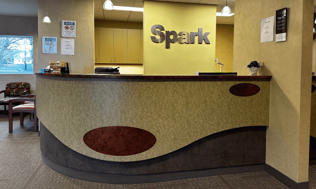 Curved reception desk with a Spark Orthodontics logo at the Camp Hill, PA office