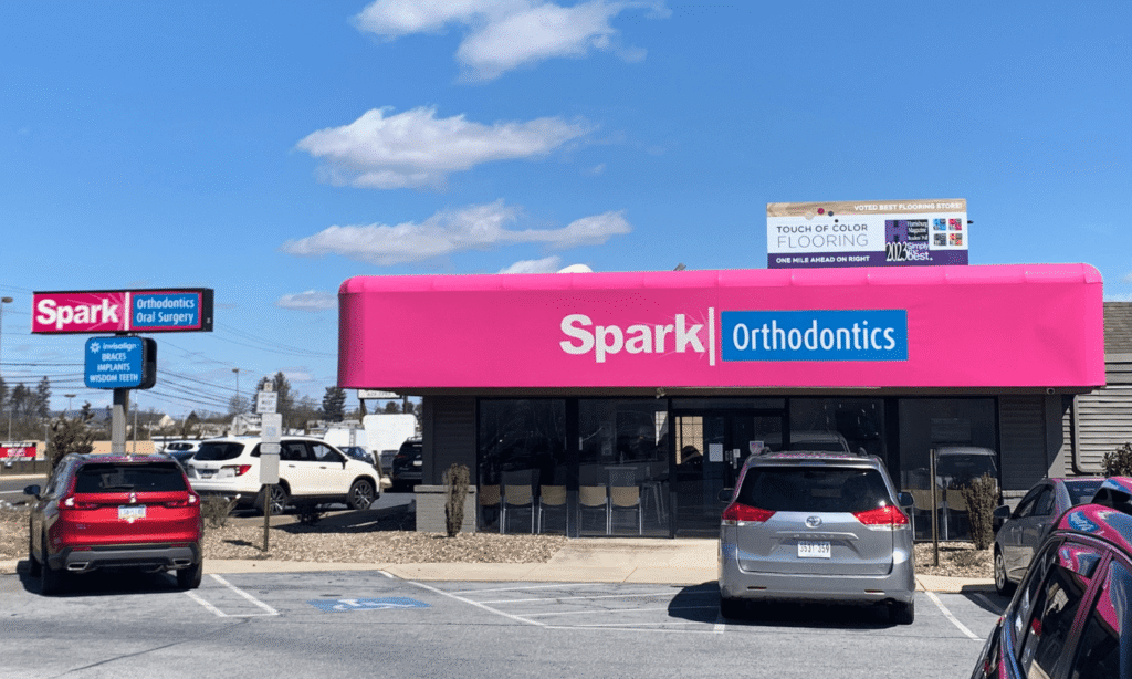 Exterior of the Spark Orthodontics Harrisburg, PA office with pink storefront awning
