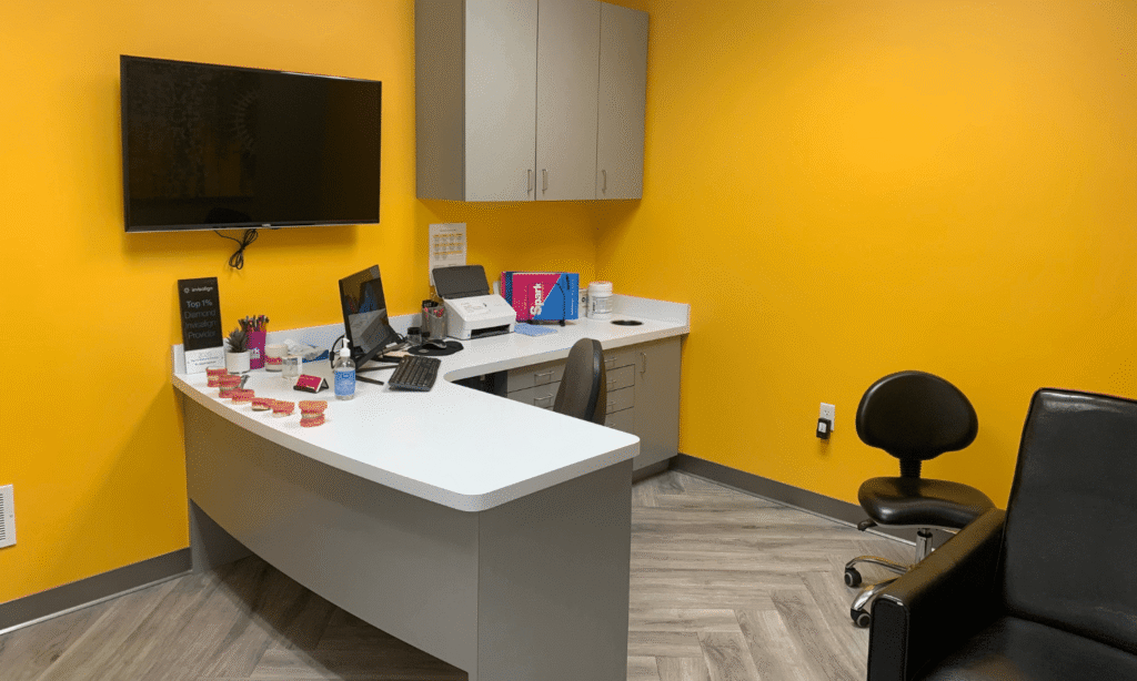 Consultation room with a yellow accent wall at the Spark Orthodontics Harrisburg, PA office