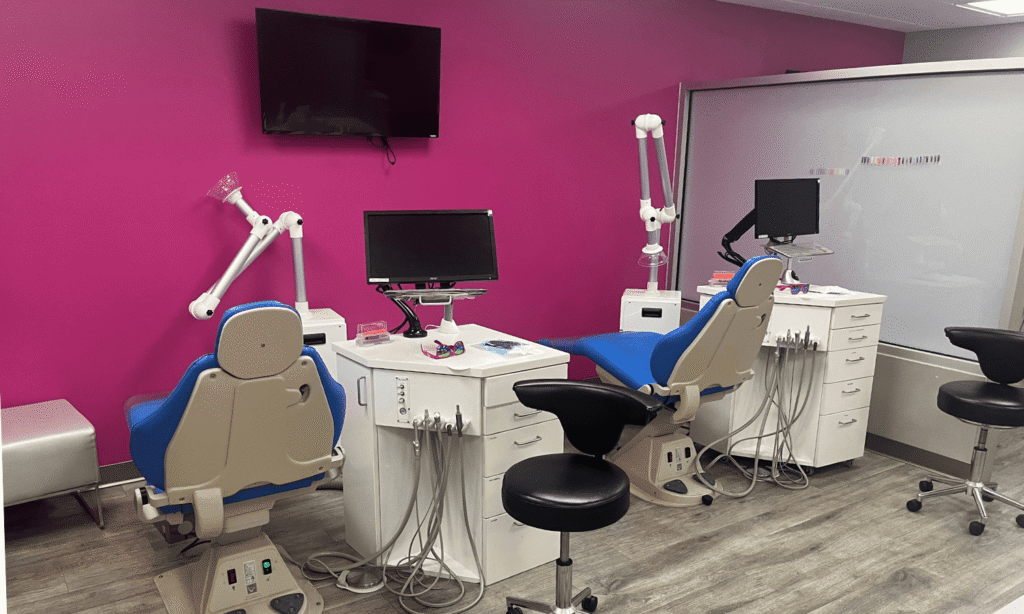 Treatment bay with a bright pink accent wall at the Spark Orthodontics Lancaster, PA office