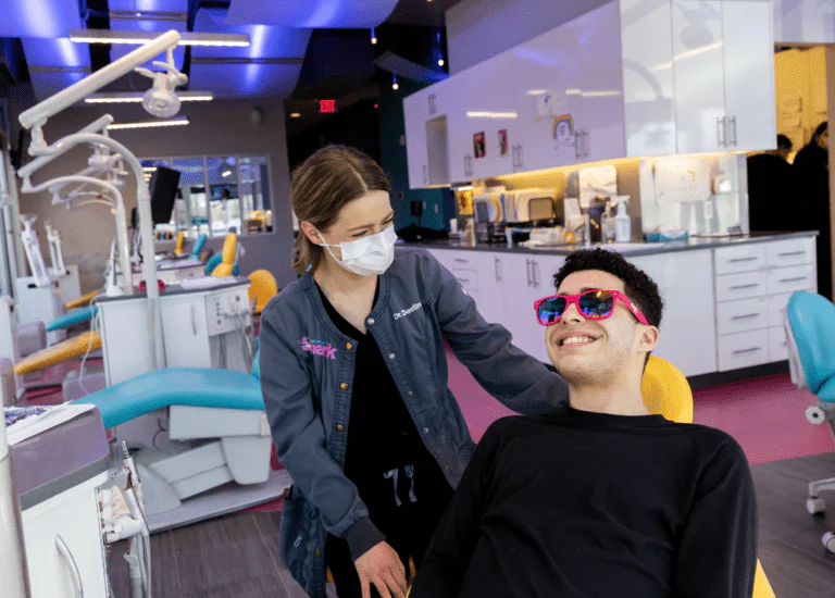Dr. Destinee Lacey with a smiling patient wearing pink sunglasses at Spark Orthodontics